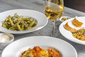 Full table of italian meals on plates and wine