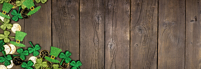 St Patricks Day corner border against a dark wood banner background. Top view with gold coins,...