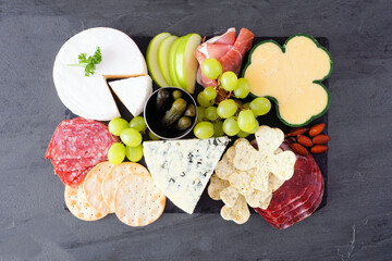 St Patricks Day theme charcuterie board against a dark slate background. Mixture of cheese, meat,...