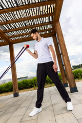 Man having resistance band workout outdoor