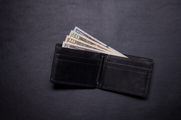 Dark leather open wallet with US dollars banknotes isolated on white background. 