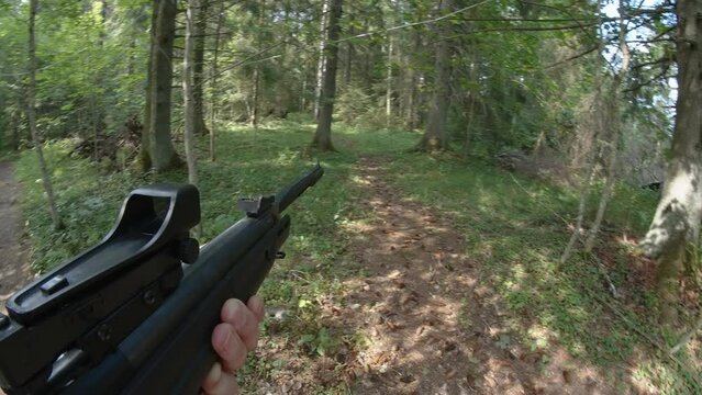The rifle gun pointing to the forest being held by the man in Estonia