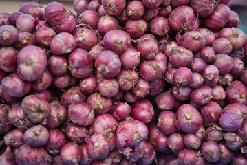 A pile of onions at a market in Hua Hin Thailand stacked and ready for sale. The onions are natural and fresh.