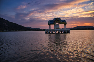 Buddhist Shrine On A Lake In Hua Hin In Thailand At Sunset! The Temel is reflected in the water and the sky turns red!