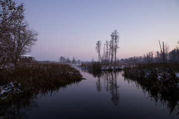 Fototapeta na wymiar Landscape with a river, in winter scenery, at the evening time.