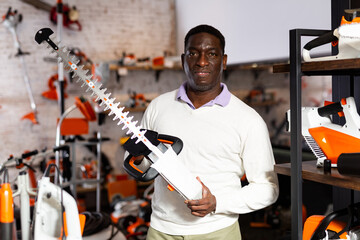 Portrait of man with an brush cutter in hardware shop
