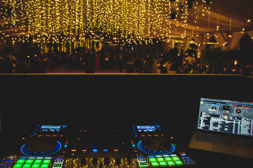 Mesa de DJ en fiesta elegante nocturna con luces de bokeh de fondo