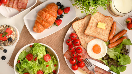 Healthy breakfast with salad bowl, croissant, a plate of American breakfast