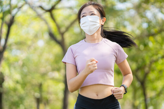 Woman runners morning exercise she wears a nose mask. Protection against dust and viruses. Outdoor run, spread the epidemic of the virus