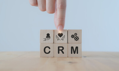 Customer relationship management (CRM)concept. Marketing strategy for customer retention and advocacy. Hand puts wooden cube with 