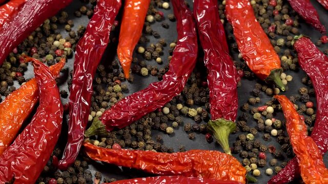 Dried red hot chili peppers with mixed peppercorns rotation background. Close up