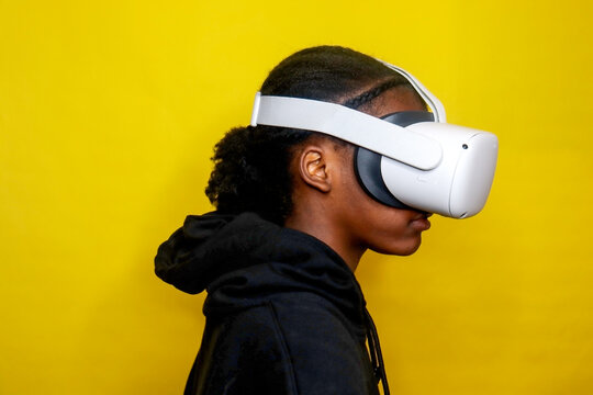 Young Kid wearing Virtual Reality Headset yellow background indoors