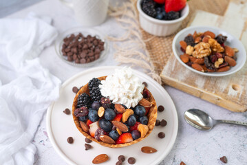 Yogurt and fruit in a waffle bowl. Greek yogurt in ice cream waffle bowl with fruit and nuts, healthy diet friendly dessert. Fruity waffle bowl.
