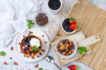 Yogurt and fruit in a waffle bowl. Greek yogurt in ice cream waffle bowl with fruit and nuts, healthy diet friendly dessert. Fruity waffle bowl.
