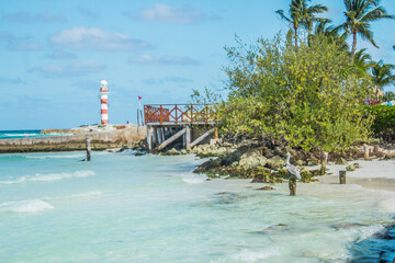 Preciosa foto de la playa, un muelle y un faro de fondo