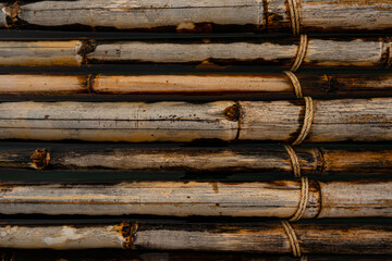 Close up of old brown bamboo raft with rope for background