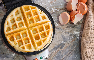 Belgium waffle homemade on waffle iron with Egg shell.