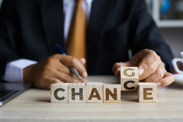 Businessman hand picking up and turning wooden cube from letter g to c, business concept from...