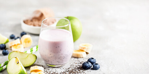 Healthy fresh smoothie protein drink from green apple, banana, chia seeds and whey protein powder in the glass. Copy space, banner - obrazy, fototapety, plakaty