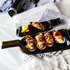 Japanese sushi food. Maki and rolls with tuna, salmon, shrimp, crab and avocado. Served on a dark glass dish from a melted black bottle