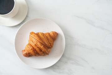 fresh croissant on white plate