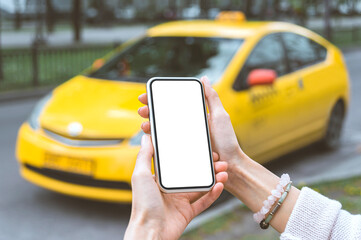 Mock-up, a smartphone in the hands of a girl. against the backdrop of a yellow taxi.