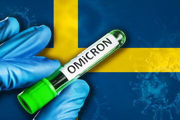 Sweden outbreak of omicron variant. Hand holds a test tube with covid-19 virus omicron in front of...