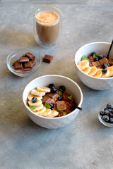 chocolate oatmeal porridge with blueberry, mint leaves and banana in a bowl. breakfast Concept