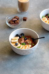 chocolate oatmeal porridge with blueberry, mint leaves and banana in a bowl. breakfast Concept
