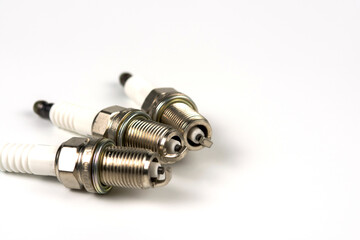 A set of new car spark plugs as a spare part of motor vehicles on white. Group of candles for the engine close-up. Copy space