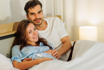 Obraz premium Cheerful pregnant wife smile and happy as beloved husband give love by warm hug on belly of unborn baby and adore her maternity