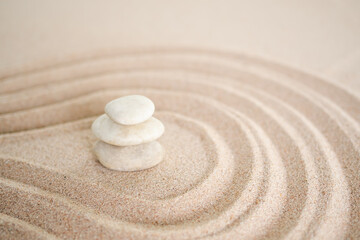 Stacks of pebbles with  pattern Zen japanese garden design on sand beach. Buddhism mind-scape calm stone symbols.