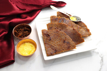 Sweet roti made out of rice flour, jaggery, and ghee. Gud ki roti. gur ki roti, jaggery Bhakri, meethi gud ki roti cooked in banana leaf. Winter food. Copy space.