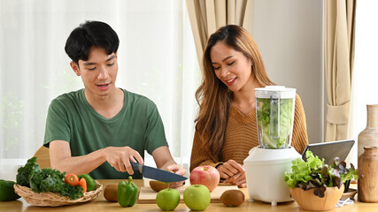 Young asian couple making detox smoothie at home. Healthy food concept.