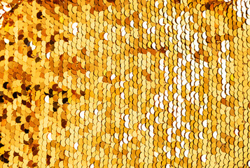 Golden sequins macro background. Sparkling sequined textile. Abstract texture scales with shiny...