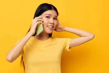 pretty brunette talking on the phone posing technology yellow background unaltered