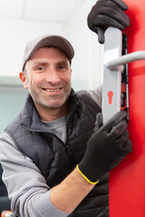 portrait of mature worker installing doors