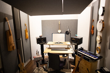 Music studio full of instruments and pc display