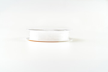 thread reel for weaving and needlework from beads on a white background. accessories for creating costume jewelry. sale of goods for creativity and needlework.