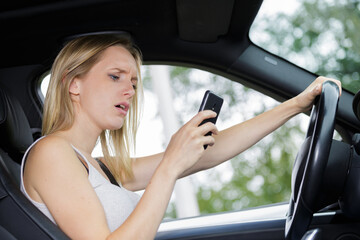 Fototapeta na wymiar a woman texting while driving