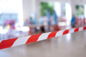 Row of empty red chairs and warning tape infection area.No entry sign concept.Selective focus.