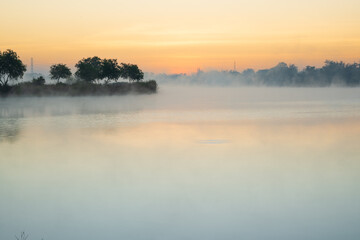 Morning time on the lake and mist fog.The trees and foggy with sun rise sky and reflective in the water.Natural landscape in the morning time.