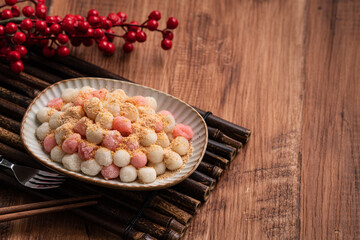 Deep-fried red and white tangyuan with peanut powder.