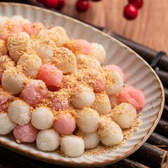 Deep-fried red and white tangyuan with peanut powder.