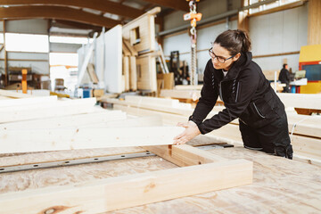 Woman worker in a carpentry workshop manufacturing prefabs - 481761096