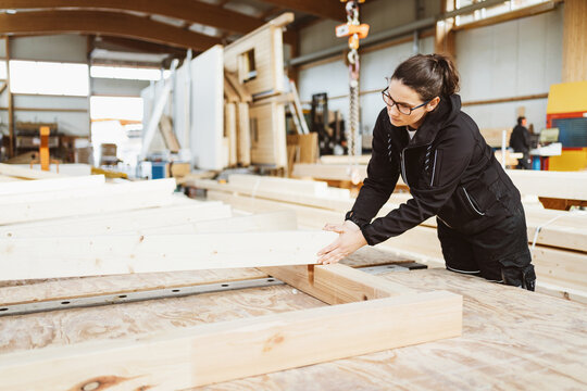 Woman worker in a carpentry workshop manufacturing prefabs