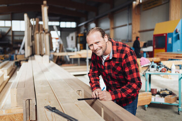 Male carpenter in a woodworking workshop or factory