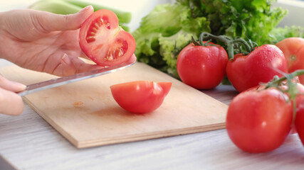 woman holding fresh juicy tomatoes hands close up, vegetables and and lettuce on background