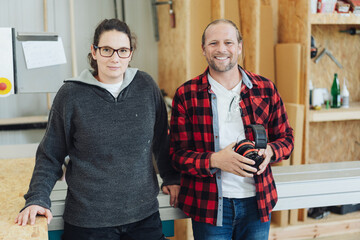 Work team in a woodworking factory with friendly man and woman