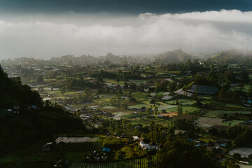 View of the foothills of Mount Batur, Bali, Indonesia from the top of a hill in a foggy morning